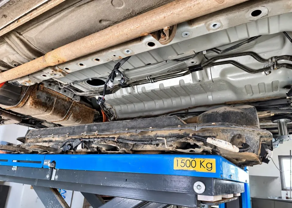 Bateria Mitsubishi Outlander PHEV pe masa de ridicare, sub caroseria mașinii